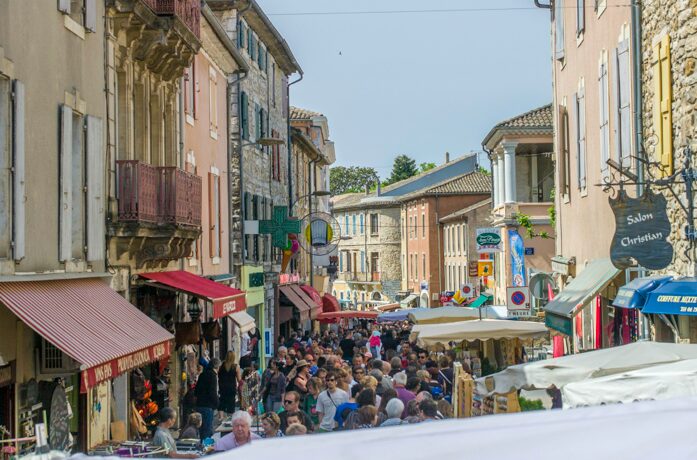 Marktkramen en drukte in de hoofdstraat van Vallon-Pont-d'Arc